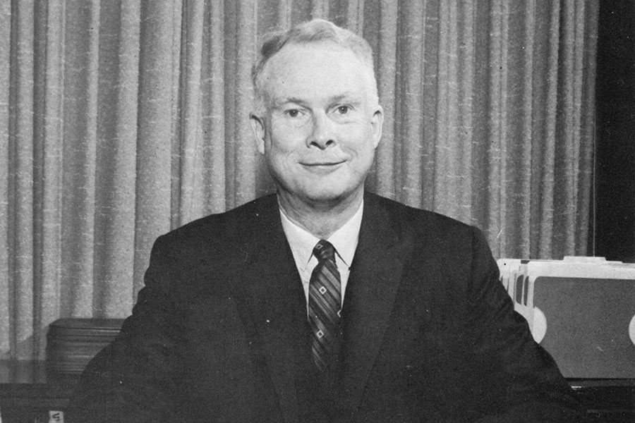 W. Allen Wallis posing for the camera at his desk.